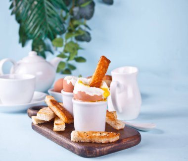 Tahtada yumurta içinde haşlanmış yumurta ve çıtır ekmek..