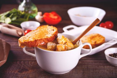 Peynir ya da soğan kremalı çorba, kızarmış ekmek ve beyaz kase.