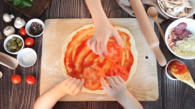 Çocuklar mutfağında pizza yapıyor. Üst görünüm.