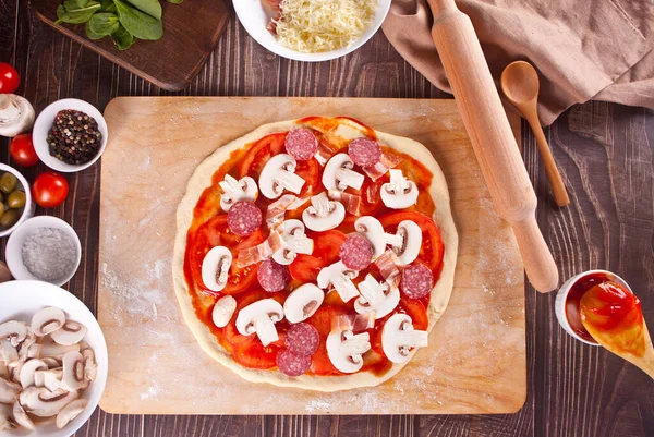 Masa cruda cruda pizza e ingredientes para pizza en el fondo de madera — Foto de Stock