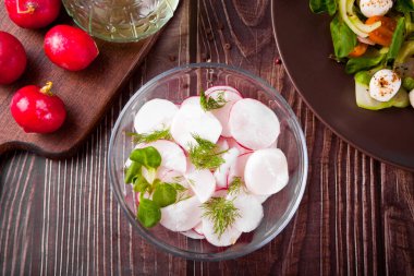 Yemek masasında turp ve fesleğenli taze salata. Üst görünüm.