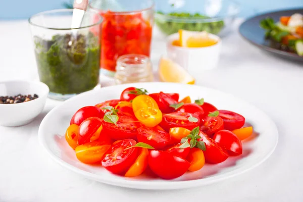 Ensalada de tomates cherry frescos con albahaca en la mesa —  Fotos de Stock
