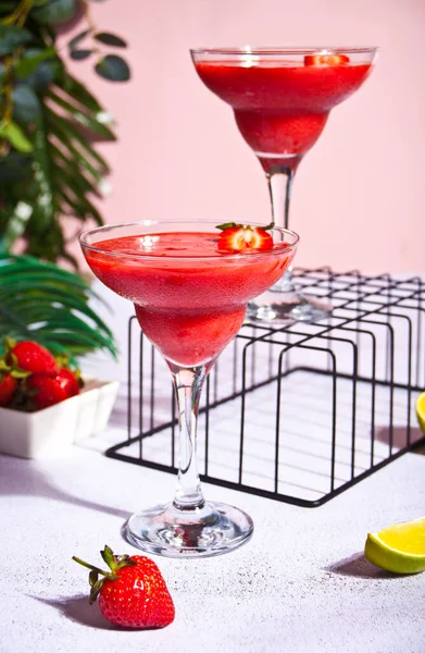 Cold strawberry margarita or daiquiri cocktails in a glasses with lime and rum — Stock Photo, Image