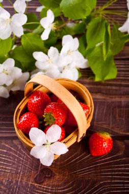 Taze olgun çilekler küçük bir sepette.