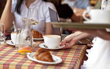 Garson elinde bir fincan kahveyle bekliyor.