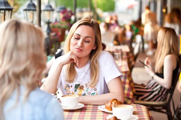 Jovem mulher em um terraço café com amigos insatisfeitos com algo — Fotografia de Stock