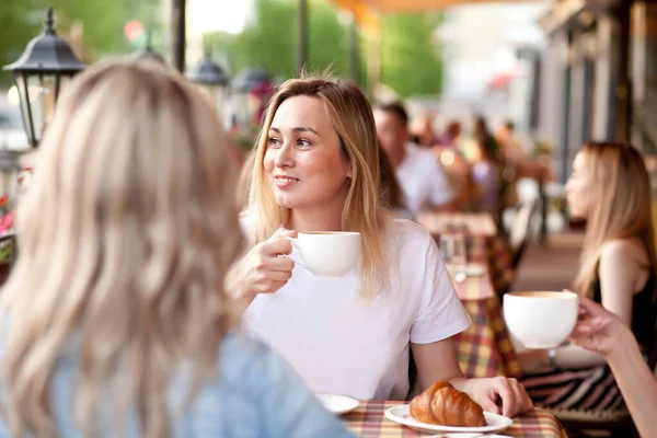 Jovem mulher bebendo um café em um terraço de café — Fotografia de Stock
