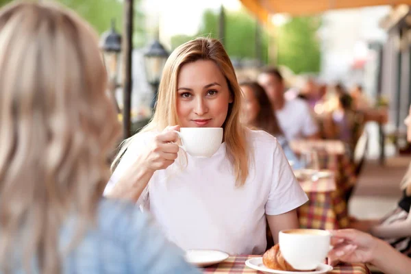 Junge Frau trinkt einen Kaffee auf einer Caféterrasse — Stockfoto