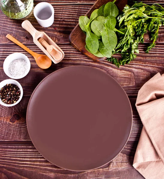 Apparecchiatura tavolo con piatto marrone con utensile da cucina sul tavolo di legno. Vista dall'alto. — Foto Stock