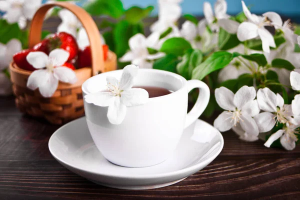 Beyaz elma çiçekli bir fincan çay. Bahar konsepti.