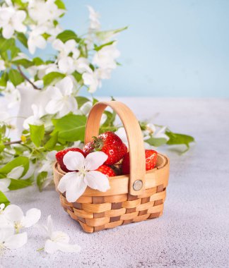 Taze olgun çilekler küçük bir sepette.