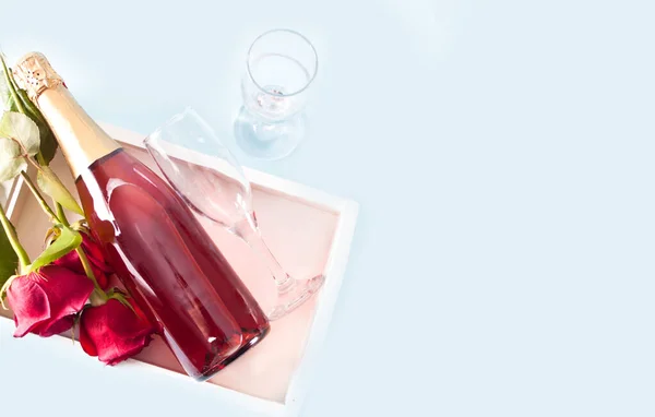 トレイにガラス付きの赤バラとワインのボトル 最上階だ スペースのコピー — ストック写真
