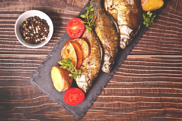 Pescado a la parrilla en plato con limón y verduras —  Fotos de Stock