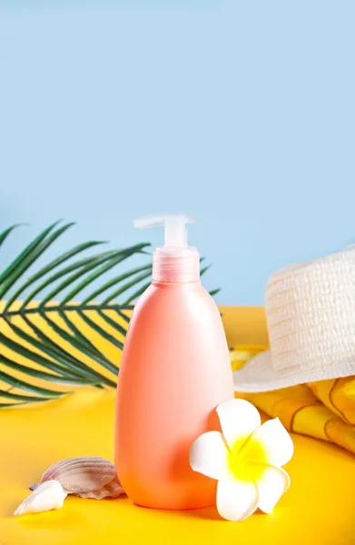 Summer beach accessories. Hat, tube of sunscreen, flower plumeria frangipani, palm leaf and seashells. — Stock Photo, Image