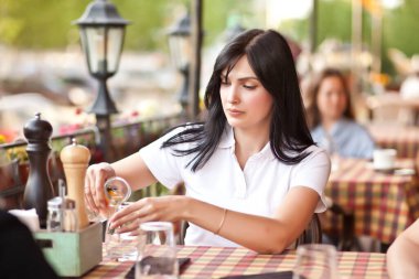 Güzel, genç, esmer bir kadın arkadaşlarıyla kafede oturuyor. İletişim ve arkadaşlık kavramı