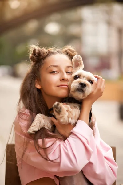 Teenager Mädchen umarmt kleinen Hund in einem Park im Freien — Stockfoto