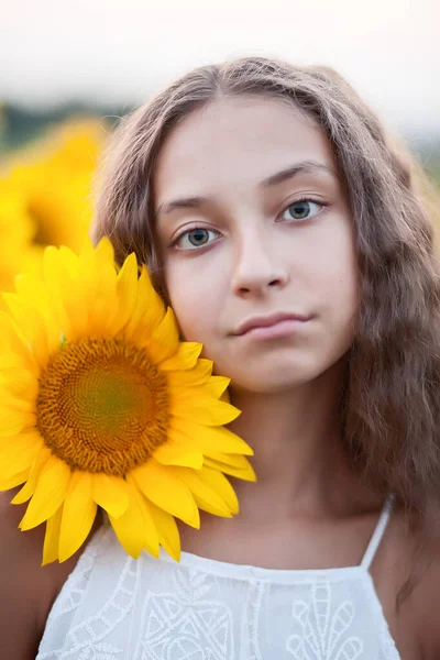 Adolescent fille portrait visage dans tournesols champ — Photo
