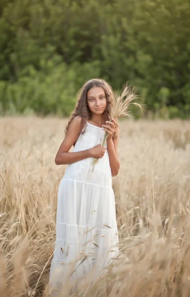 Teen girl in wheat field in a summer day — ストック写真