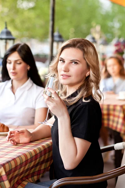 Jovem sorrindo no café bebendo vinho branco. Conceito de comunicação e amizade. — Fotografia de Stock