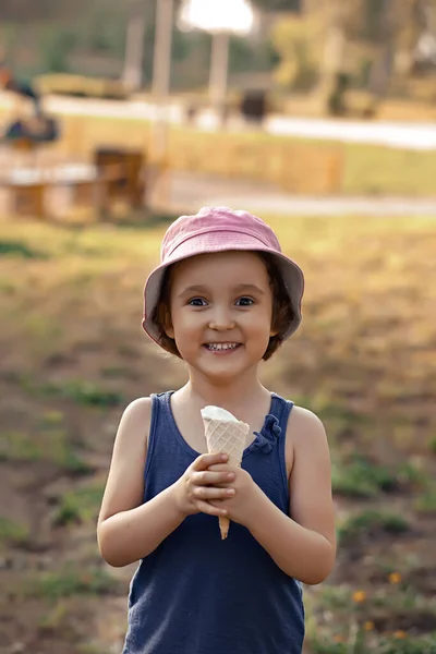 Мила дівчинка в капелюсі, що їсть морозиво — стокове фото
