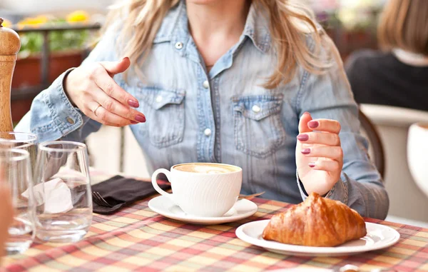 Mulher bebendo um café com croissant em um terraço café — Fotografia de Stock