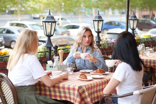 Jovens mulheres bebendo um café em um terraço de café. — Fotografia de Stock
