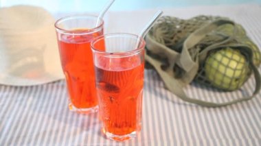 Yaz ferahlatıcı içecek kokteyli piknikte, ağ torbasında yeşil elmalarla birlikte, bir kadın eli yakına güneş gözlüğü koydu..