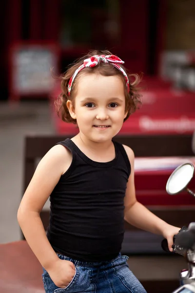 Vacker liten flicka i en cyklist stil på en motorcykel — Stockfoto