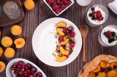 Süzme peynir ve tahıllı yoğurt, sağlıklı kahvaltı için meyve ve kayısı..