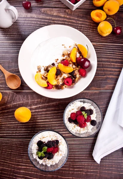 Queso cottage y yougurt con granola, bayas y frutas albaricoque para un desayuno saludable. — Foto de Stock