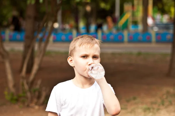 Petit garçon enfant boire de l'eau d'une bouteille en plein air dans un parc — Photo