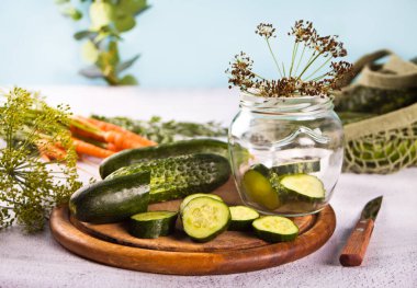 Mutfak masasında salatalık turşusu, baharat ve sarımsak.