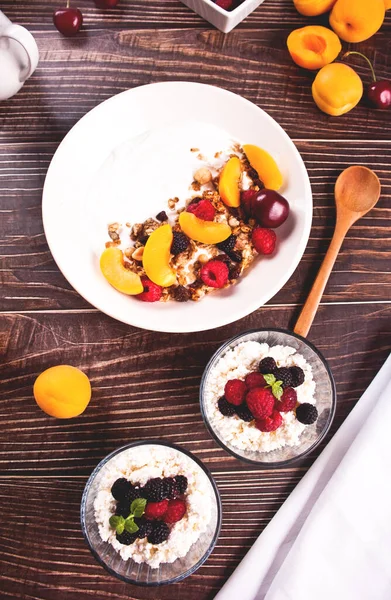 Queso cottage y yougurt con granola, bayas y frutas albaricoque para un desayuno saludable. — Foto de Stock