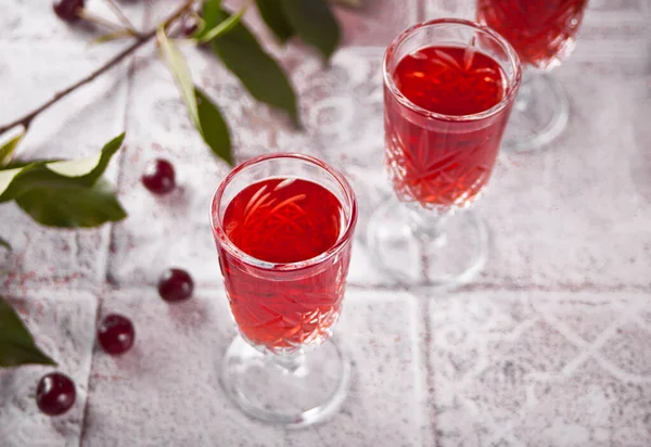 Glasses of cherry brandy liqueur with ripe berries — Stock Photo, Image