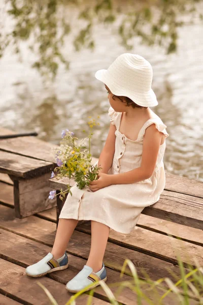 Pequena menina feliz na aldeia perto de rio ou lago. Verão país vida. — Fotografia de Stock