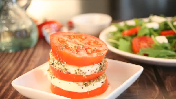 Woman hand decorated with basil leaf herb caprese salad with mozarella cheese, tomatoes and basil — Vídeos de Stock