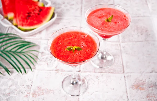 Watermelon refreshing summer frozen cocktail smoothie with watermelon slices and pieces on the background — Stock Photo, Image