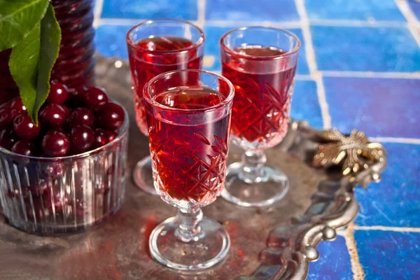 Glasses of cherry brandy liqueur with ripe berries — Stock Photo, Image