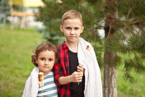Teen chlapec a dívka dítě jíst pečené marshmalloy venkovní v táboře. Cestování, túra, dovolená, koncept kempování. — Stock fotografie