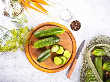 Mutfak masasında salatalık turşusu, baharat ve sarımsak.