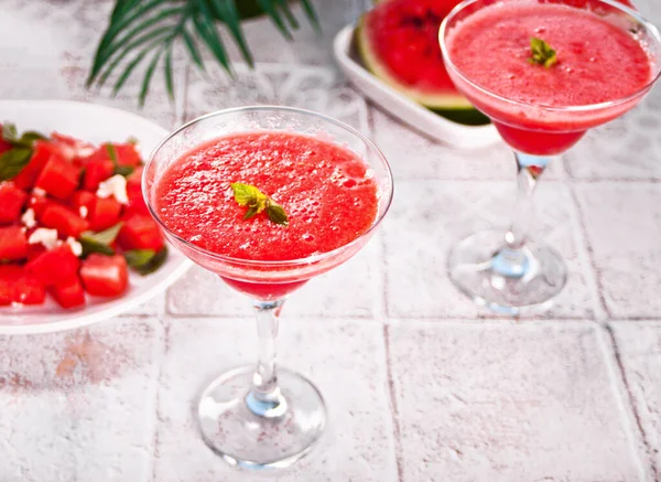 Watermelon refreshing summer frozen cocktail smoothie with watermelon slices and pieces on the background — Stock Photo, Image