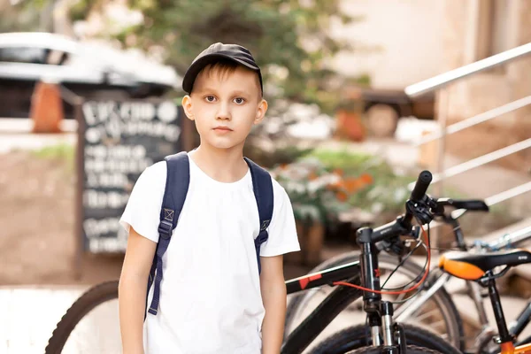 Jongen met pet in de buurt van fietsen — Stockfoto