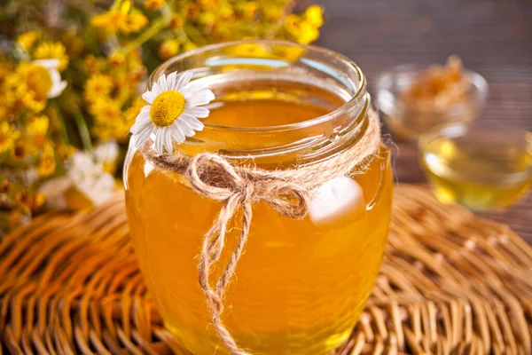 Honing in pot met wilde bloemen boeket op de achtergrond — Stockfoto