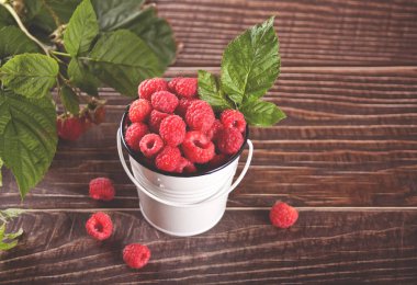 Taze olgun ahududular küçük beyaz bir kovada