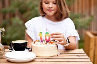 Kafe terasında doğum günü pastası olan mutlu sevimli kız. 10 yaşındaki bir çocuk doğum gününü kutlar..