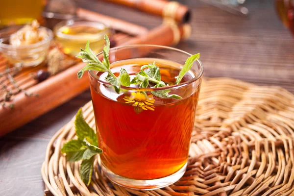 Xícara de chá de ervas com bule e bandeja de madeira com várias ervas secas — Fotografia de Stock