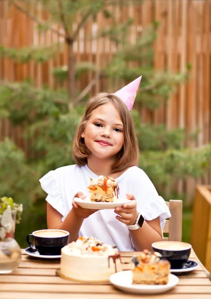 カフェテラスで誕生日ケーキと幸せな愛らしい女の子 10歳の誕生日 — ストック写真