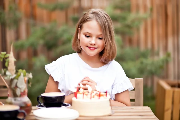 カフェテラスで誕生日ケーキと幸せな愛らしい女の子 10歳の誕生日 — ストック写真