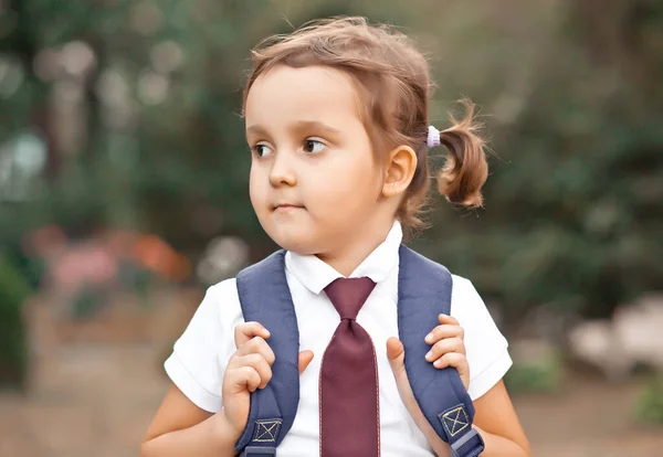 Malá roztomilá školačka v uniformě se školní taškou batoh — Stock fotografie