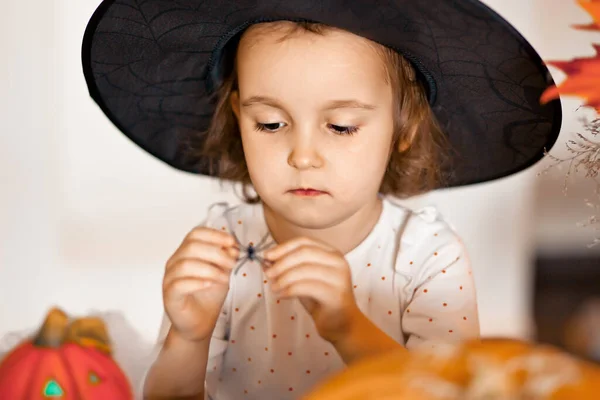 Dziecko na imprezie Halloween trzymając zabawkę pająka w dłoni. — Zdjęcie stockowe